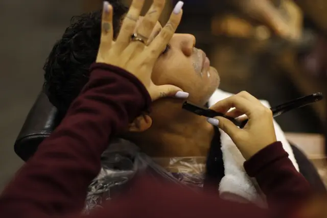 Barbiere che rifinisce una barba in salone senza prodotti riconoscibili
